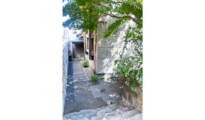 エントランスアプローチ。軟石の敷石は厚い既存軟石塀を挽き割ったもの。