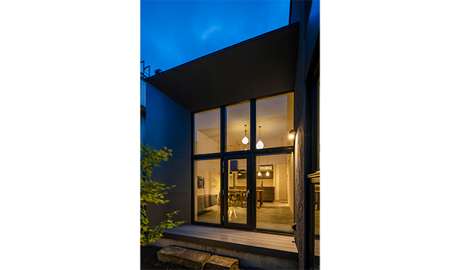 中庭よりのリビング・ダイニングキッチン夕景。