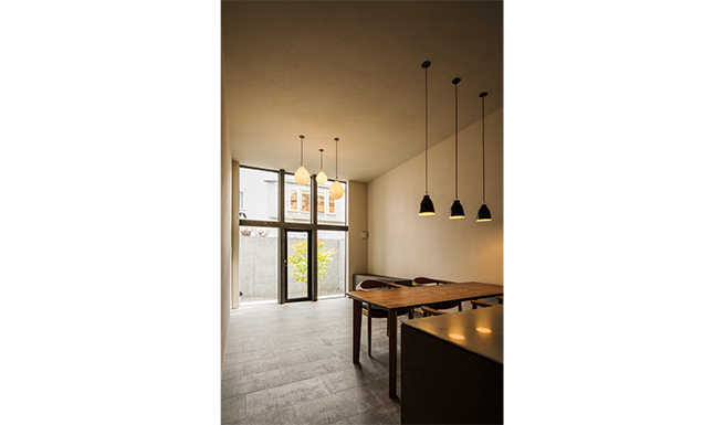 キッチンよりダイニング、リビング越しに中庭を望む。