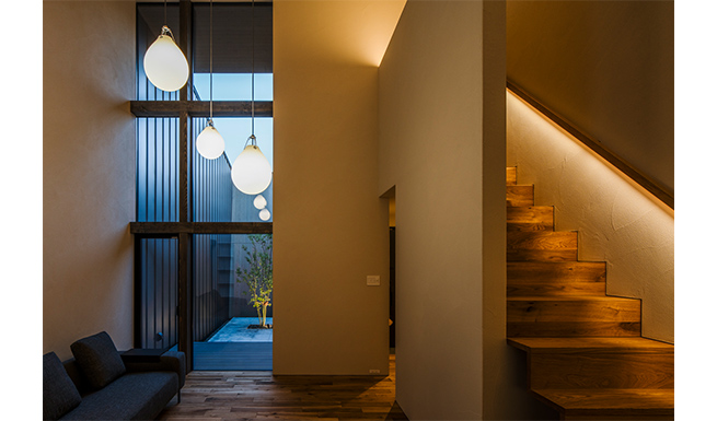 リビングと階段はハーフウォールでゆるやかに仕切られる。
