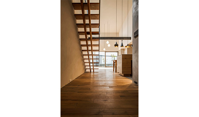 エントランスより階段越しにリビングを望む。