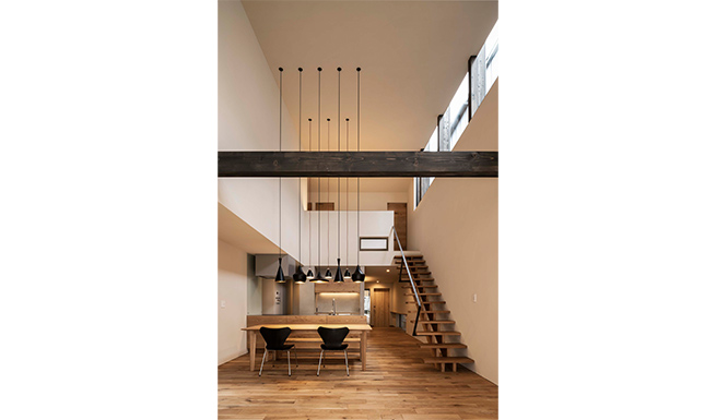 リビングからのダイニング、キッチン見返し。リビング・ダイニング・キッチンは天井高4.5m〜5.7mの吹抜を持つ開放的な空間。