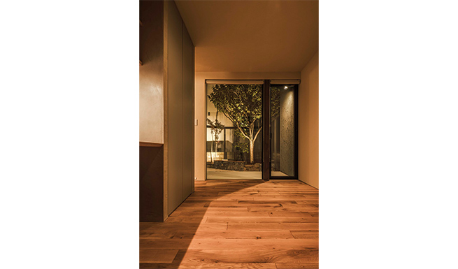 多目的ルームよりテラス越しにライトアップされた南側庭を望む。